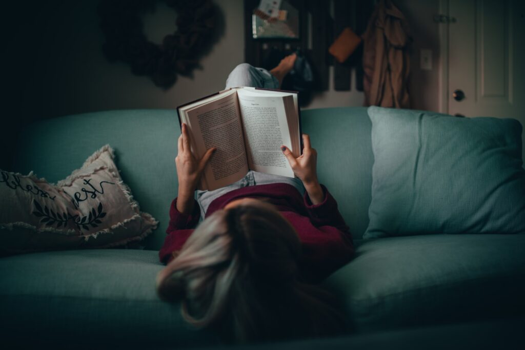 woman on couch reading book