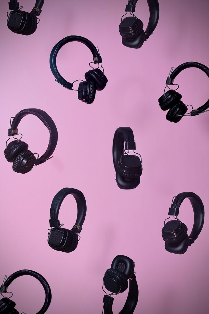 black wireless headphones pink background