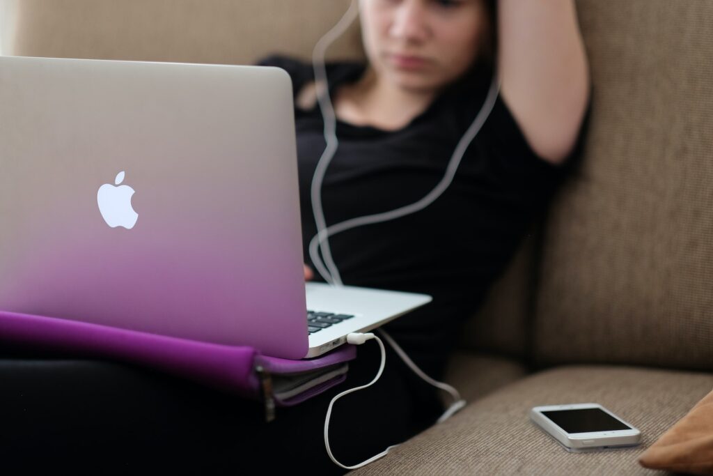 woman sitting on couch on mac computer