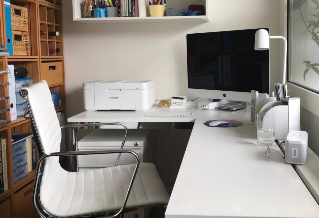 computer on desk next to printer