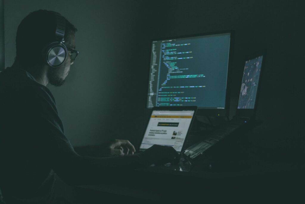 man working on multiple computers