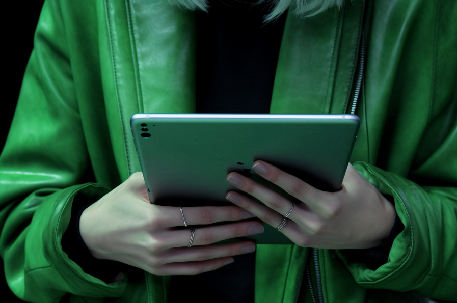 A person in green clothes holds an iPad