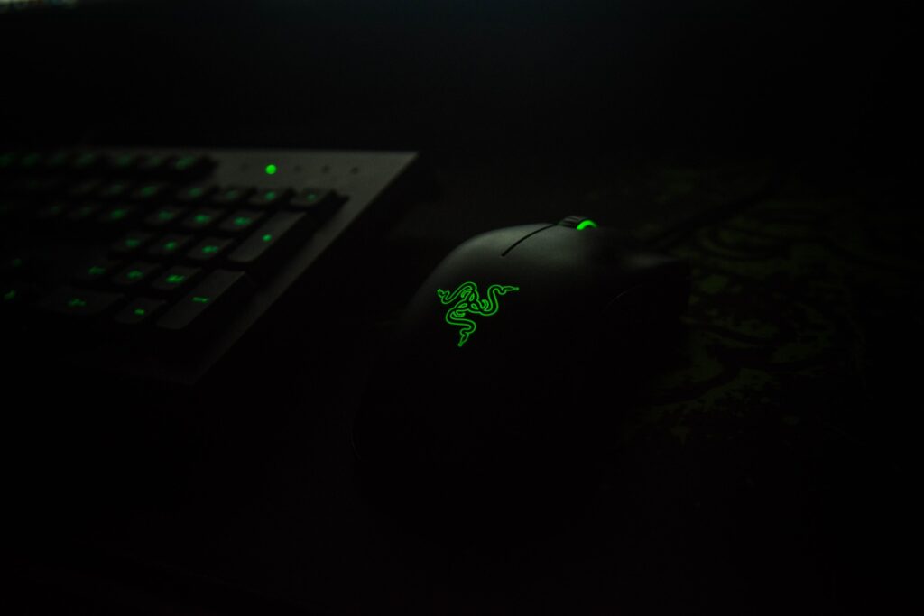 gaming keyboard and mouse in a dark room with green highlights