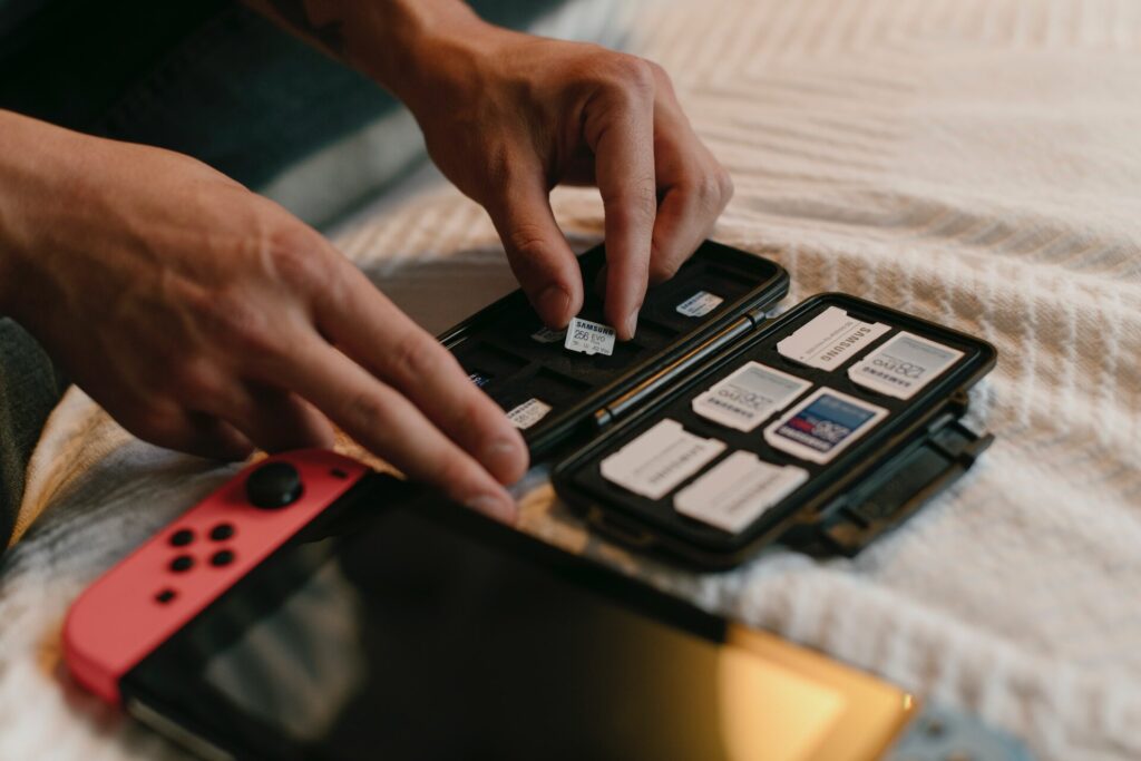 Person arranging memory cards next to a Nintendo Switch