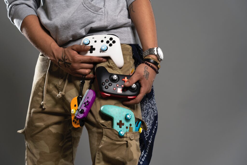 person with nintendo switch controllers attached to pants