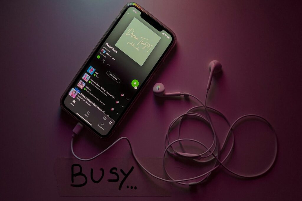 Spotify playing on a mobile phone connected to earphones