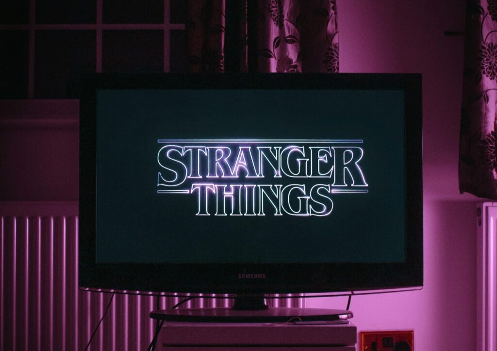 Stranger Things title on TV with purple highlights in the background.