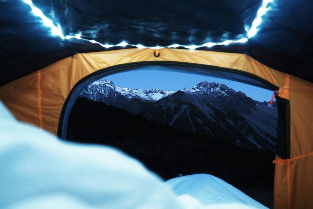 A glimpse of majestic mountains from the inside of a tent..