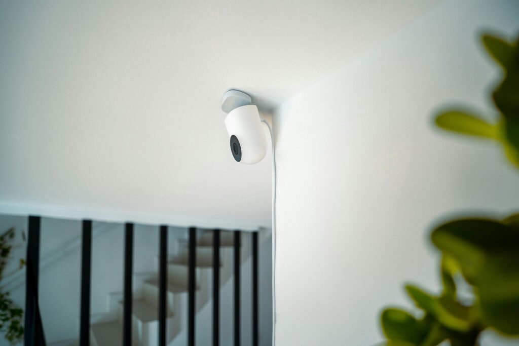 A white smart home security camera mounted securely to a wall