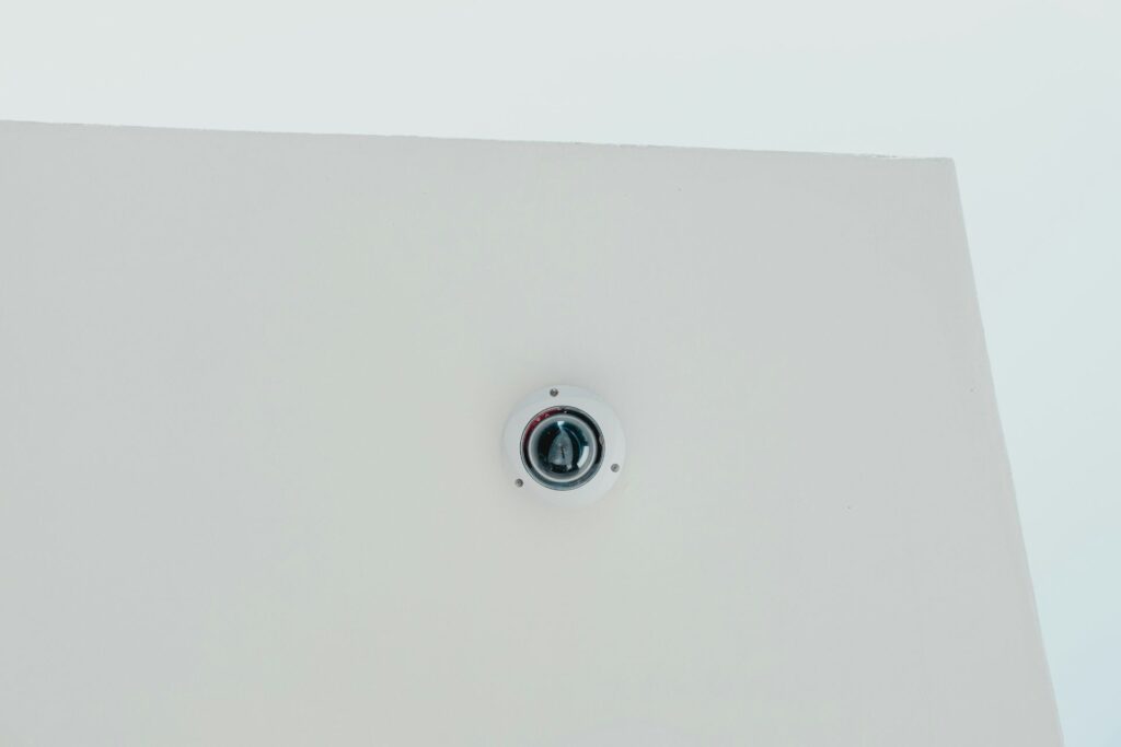 A white wall featuring a security camera affixed to its surface