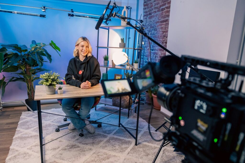 youtuber sitting on a desk being filmed for her subscribers