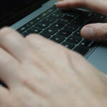 person typing on laptop keyboard
