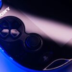 A PSP handheld sitting against a purple backdrop