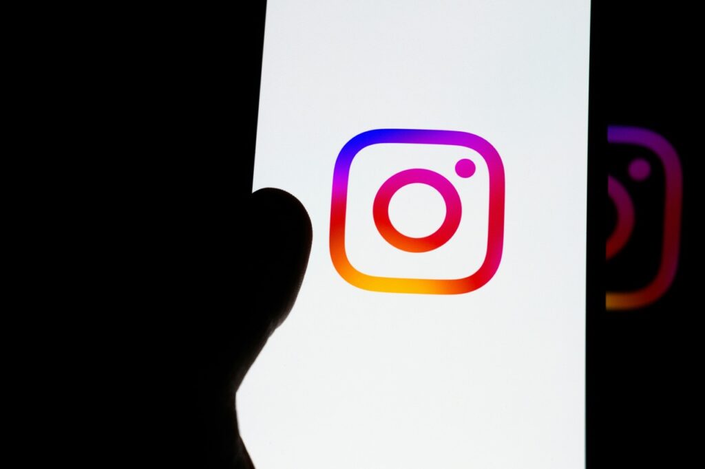 instagram logo on white background with a thumb
