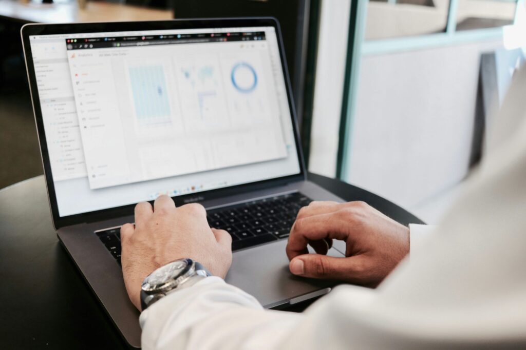 Business professional reviewing data charts and graphs displayed on a laptop